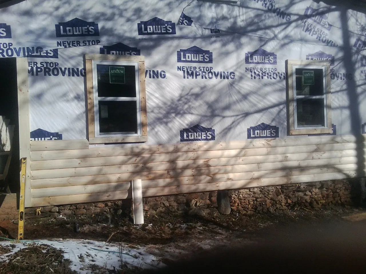 House wrap and new log siding going up on an exterior wall in Colerain