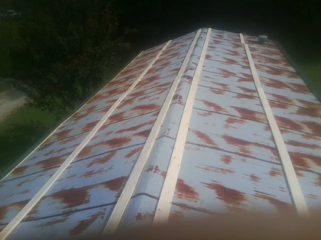 Rusted metal roof panels with new wood purlins before replacement — Storm Damage Roof Repair in Colerain by Roofing Brothers
