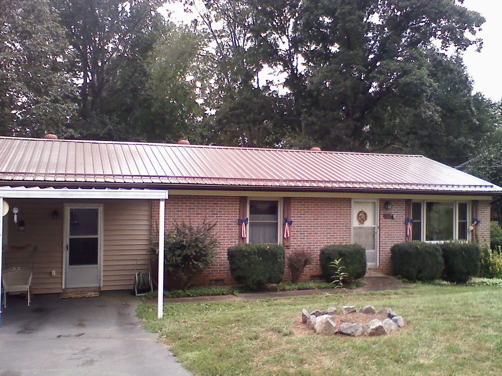 Bronze metal roof and carport on a brick ranch home — Roof Repair work by our crew in Colerain