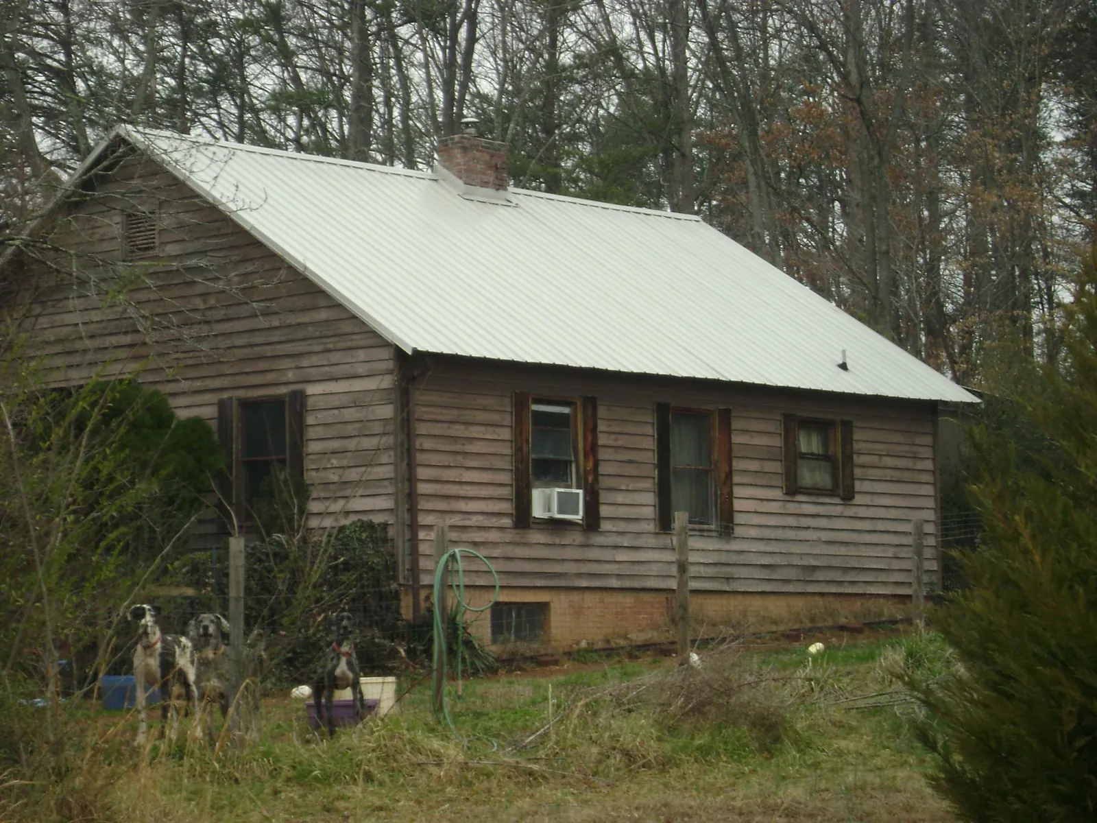 White metal roof on an old wood sided farmhouse, from a Metal Roof Installation job in Colerain